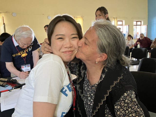 メガネを贈られた国内避難民の女性から感謝のキスを受ける佐藤副主任